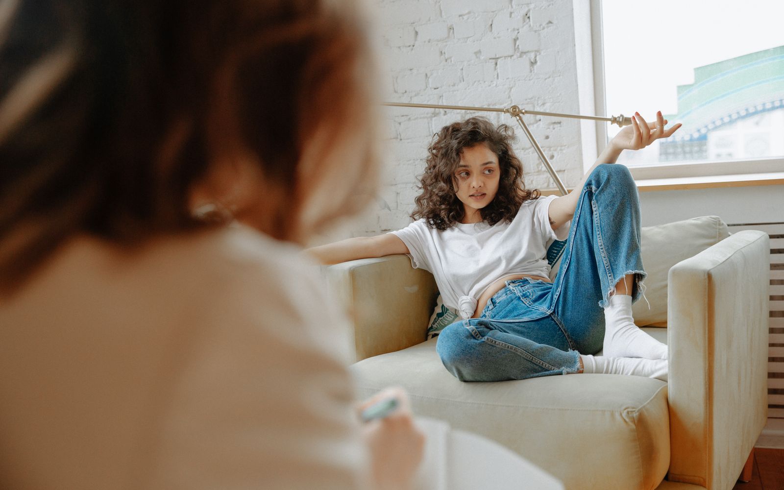 Jonge vrouw in gesprek met een begeleider aan tafel